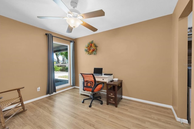 home office with light wood-style floors, baseboards, and a ceiling fan