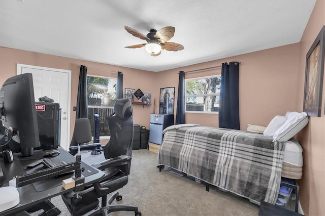 carpeted bedroom featuring multiple windows and a ceiling fan