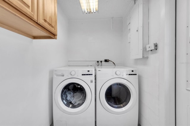 laundry area with separate washer and dryer and cabinet space