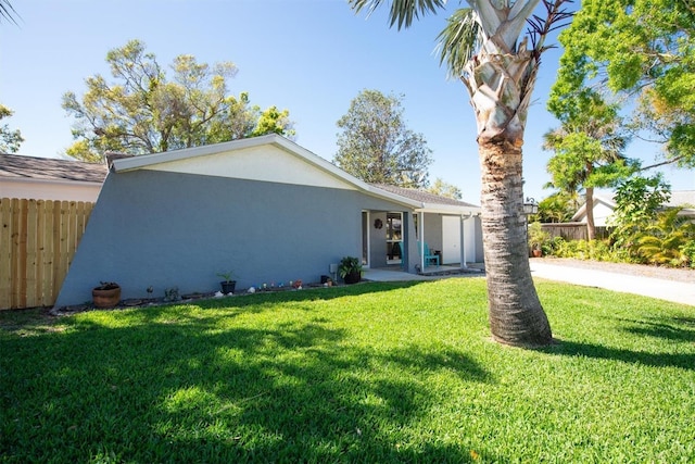 view of front of property featuring a front yard, fence, and stucco siding