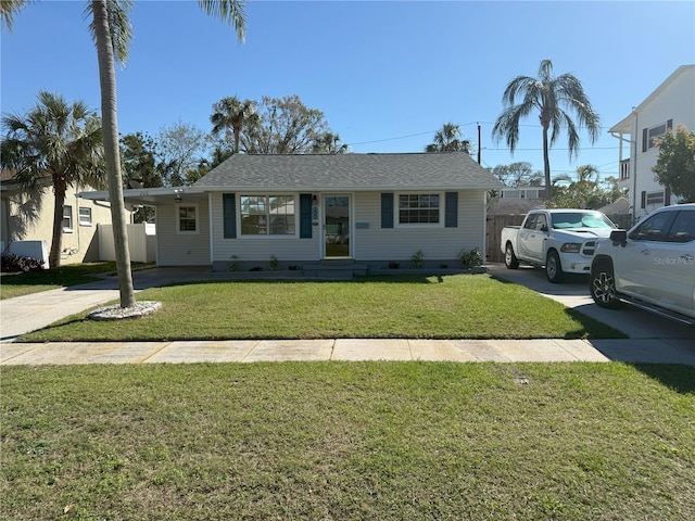 view of front of house featuring concrete driveway, a carport, and a front yard