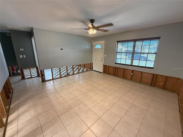 interior space featuring a ceiling fan, light tile patterned flooring, and a textured ceiling