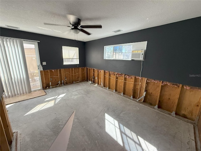 unfurnished room featuring a ceiling fan, visible vents, and a textured ceiling