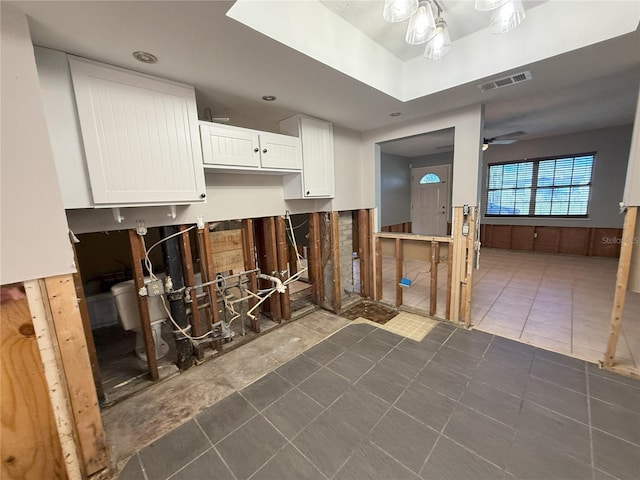 kitchen featuring visible vents, dark tile patterned flooring, white cabinetry, and a ceiling fan