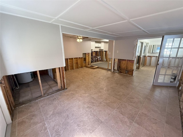 basement featuring a wainscoted wall, ceiling fan, and wooden walls