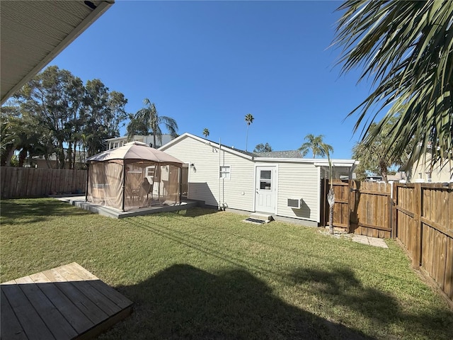 back of house with a fenced backyard, a lawn, and a gazebo