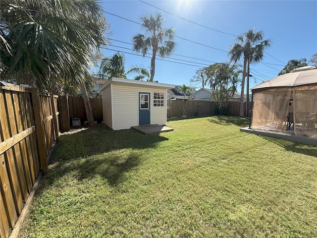 view of yard with an outbuilding, a gazebo, and a fenced backyard