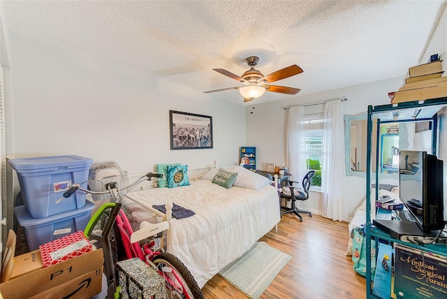 bedroom featuring a ceiling fan, a textured ceiling, and wood finished floors