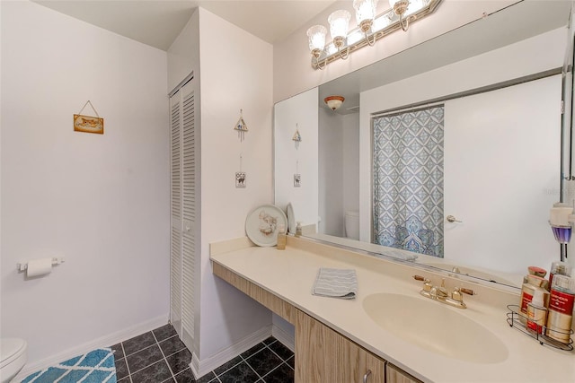 full bathroom featuring a closet, toilet, vanity, tile patterned flooring, and baseboards