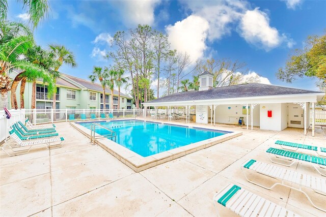 pool with a patio area and fence