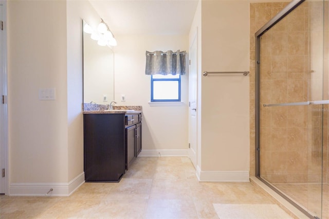 bathroom with tiled shower, tile patterned floors, vanity, and baseboards