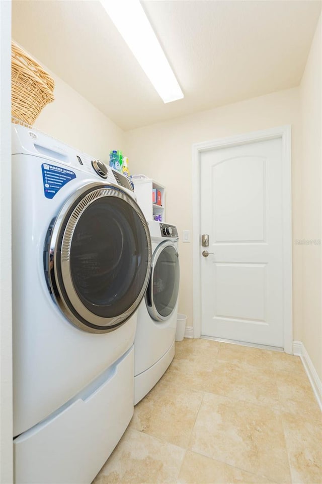 laundry area with washing machine and dryer, laundry area, and baseboards