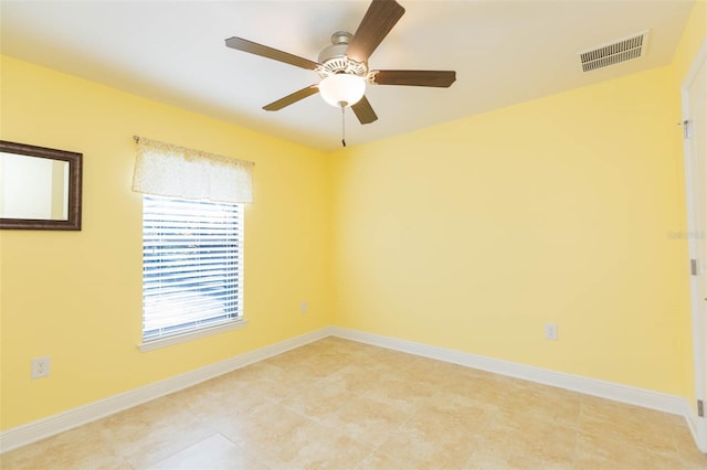empty room featuring visible vents, ceiling fan, and baseboards