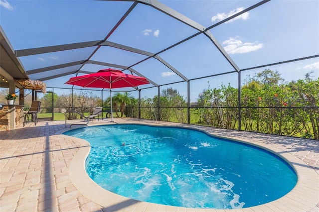 pool with outdoor dry bar, glass enclosure, and a patio area