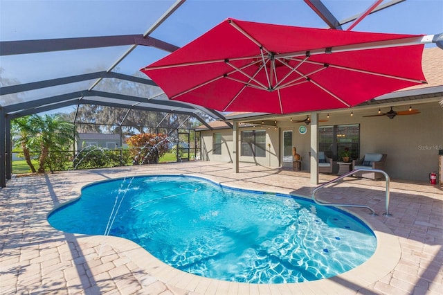 outdoor pool featuring glass enclosure, a ceiling fan, and a patio