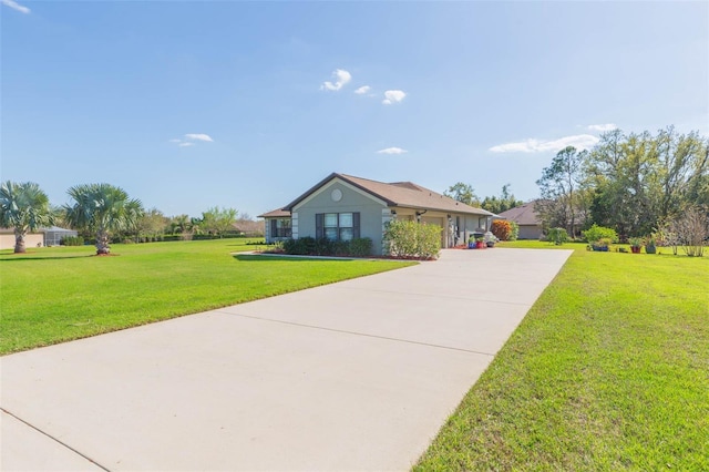 ranch-style house with a garage, concrete driveway, and a front yard