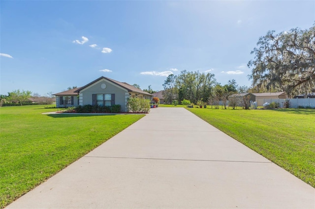 ranch-style home with driveway and a front lawn