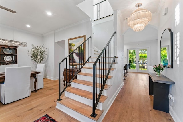 entryway featuring a notable chandelier, stairway, french doors, and hardwood / wood-style floors