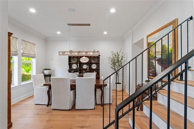 dining area with wood finished floors, recessed lighting, ornamental molding, and stairs