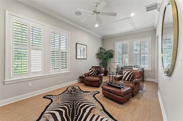 sitting room with baseboards, attic access, crown molding, visible vents, and ceiling fan