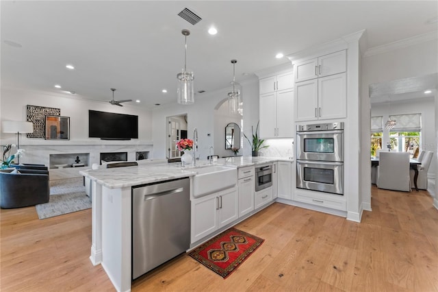 kitchen with a peninsula, a ceiling fan, white cabinets, visible vents, and stainless steel appliances