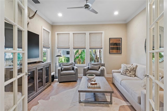living area with crown molding, light wood-style flooring, recessed lighting, and ceiling fan