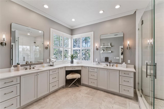 bathroom featuring a sink, two vanities, a shower stall, and crown molding