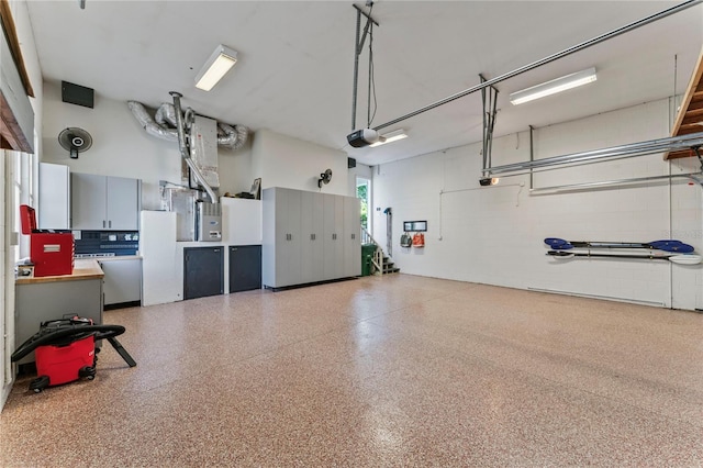 garage featuring a garage door opener and concrete block wall