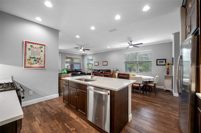 kitchen featuring a sink, ornamental molding, dark brown cabinetry, dark wood-type flooring, and stainless steel appliances