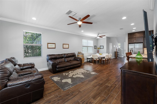 living room with visible vents, baseboards, dark wood finished floors, and ornamental molding