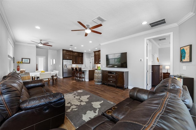 living area featuring visible vents, crown molding, and dark wood-type flooring