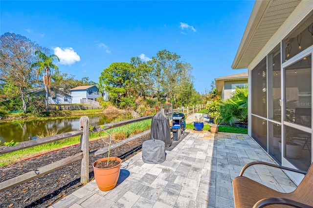 view of patio / terrace featuring fence and a water view