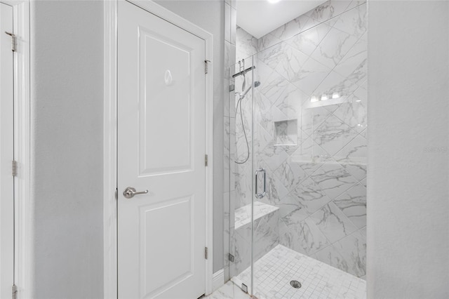 bathroom featuring a marble finish shower