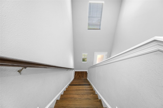 stairway featuring wood finished floors and baseboards