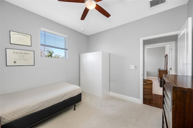 carpeted bedroom featuring visible vents, a ceiling fan, and baseboards