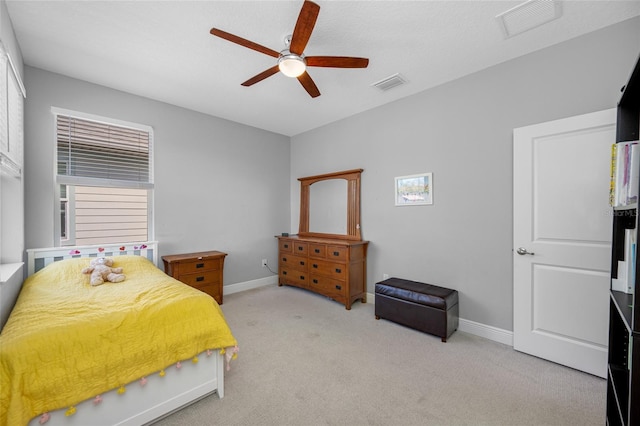 bedroom with baseboards, visible vents, and light carpet