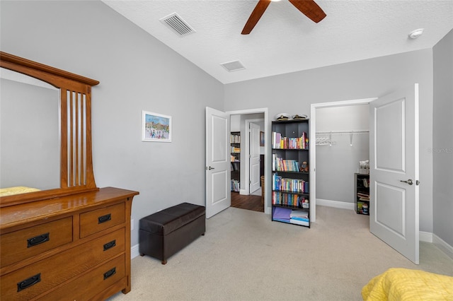 bedroom featuring visible vents, light carpet, a textured ceiling, a closet, and baseboards