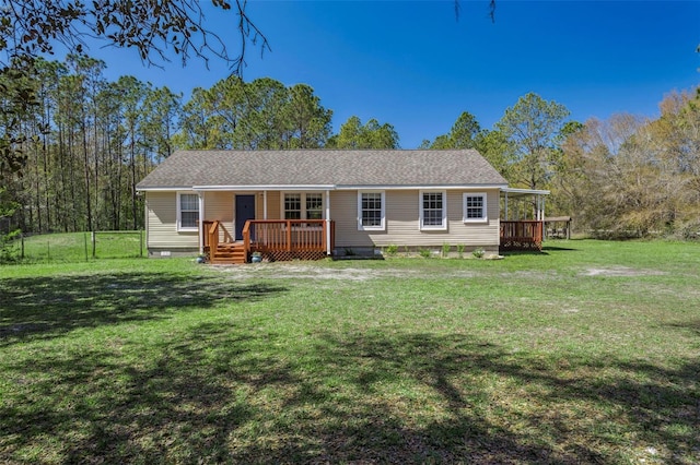 view of front of property featuring a shingled roof, a front lawn, a deck, and fence