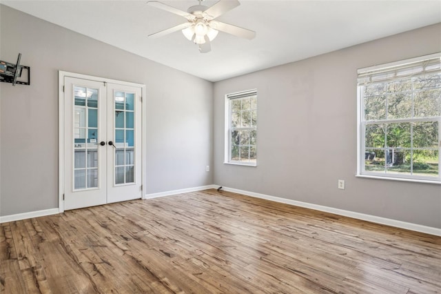 empty room featuring plenty of natural light, french doors, lofted ceiling, and wood finished floors