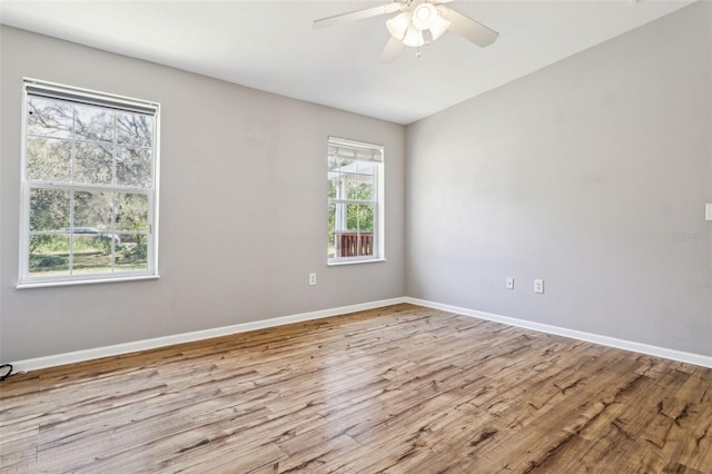 empty room featuring ceiling fan, baseboards, and wood finished floors