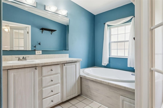 full bath with tile patterned floors, a garden tub, and vanity