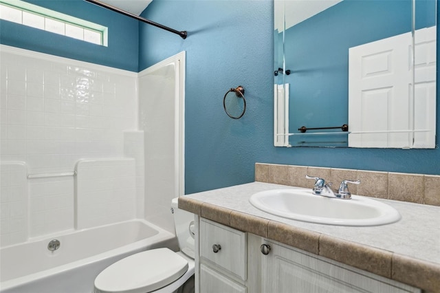 full bathroom featuring vanity, toilet, a textured wall, and shower / bath combination