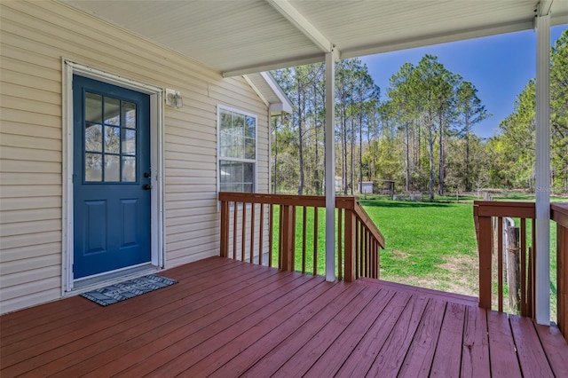 wooden terrace featuring a lawn