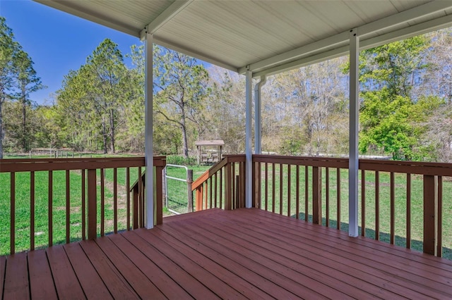 wooden terrace featuring a lawn