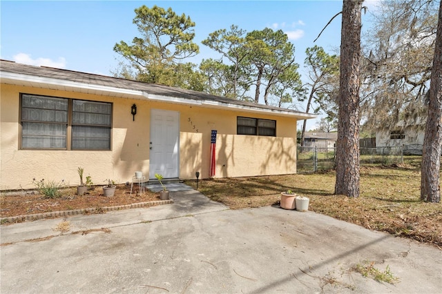 view of front of property with fence and stucco siding