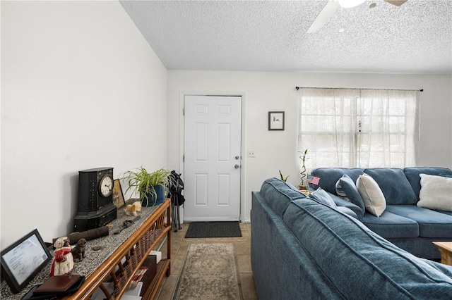 living room with a ceiling fan, a textured ceiling, and tile patterned floors