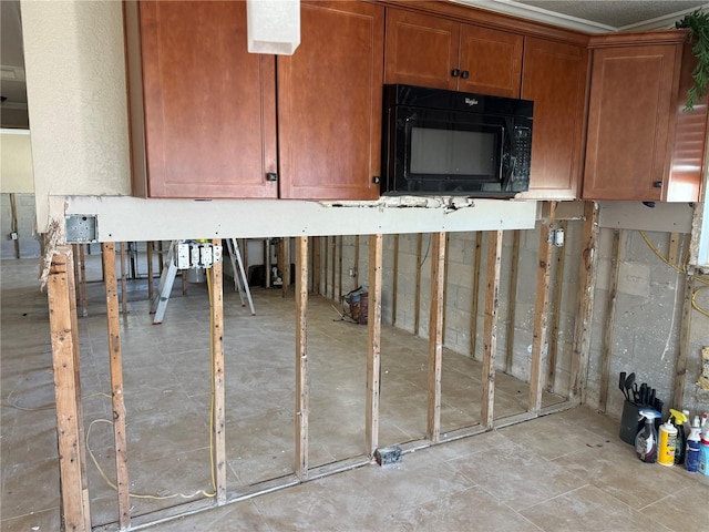 kitchen featuring black microwave and brown cabinetry