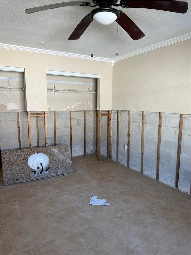 empty room featuring a textured ceiling, ceiling fan, and ornamental molding