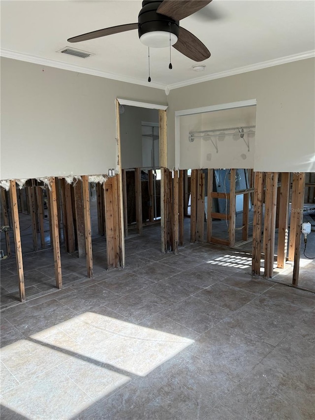 interior space with visible vents, ornamental molding, and a ceiling fan