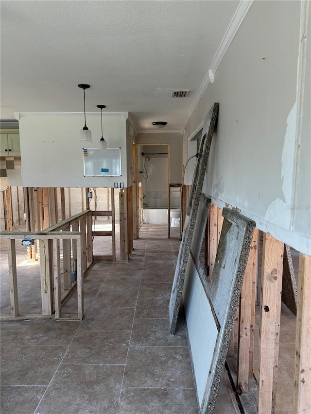 hall with visible vents, ornamental molding, and a textured ceiling